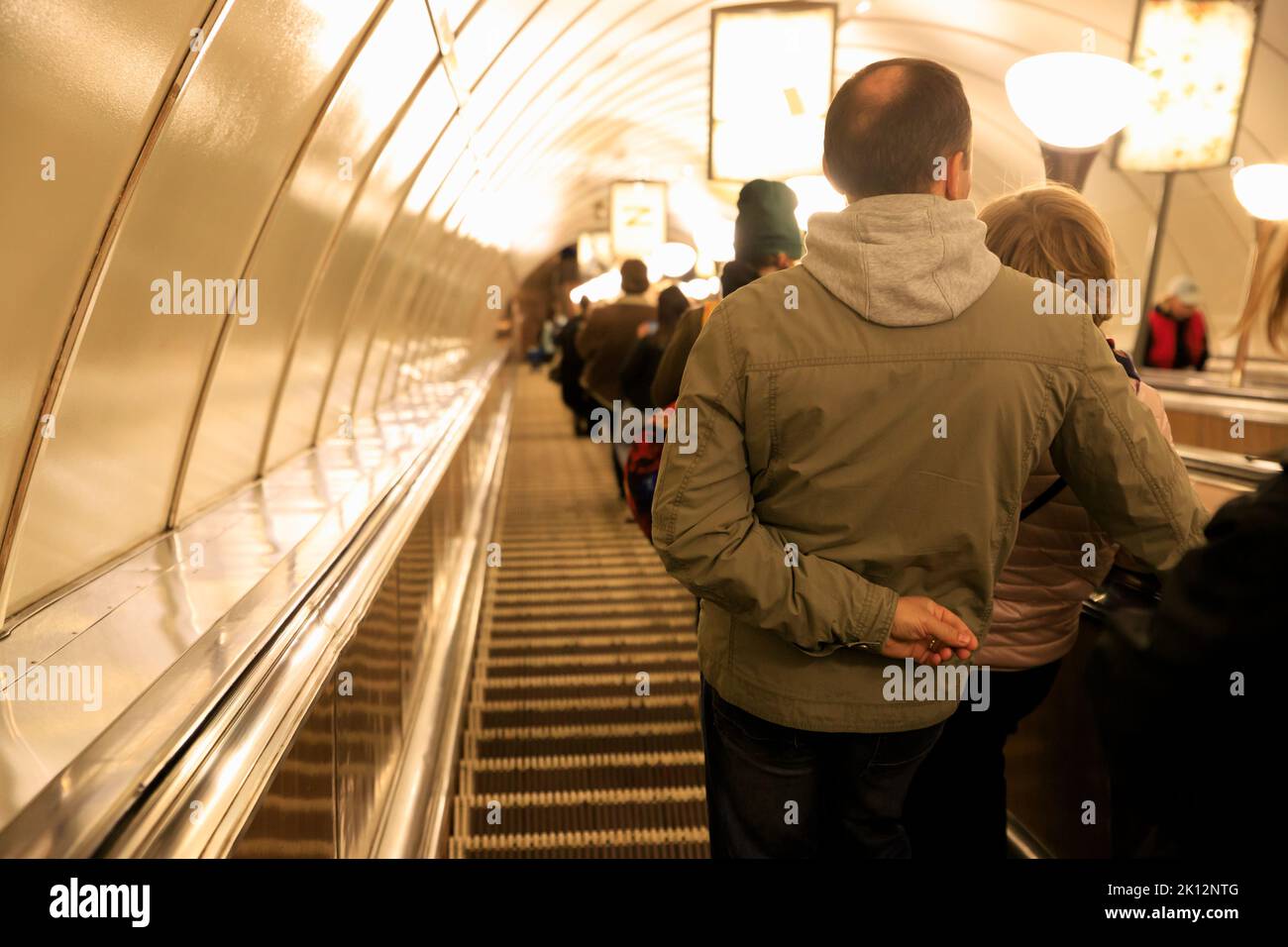 Zurück gedrehte Leute gehen die U-Bahn auf der Rolltreppe hinunter. Selektiver Fokus Stockfoto