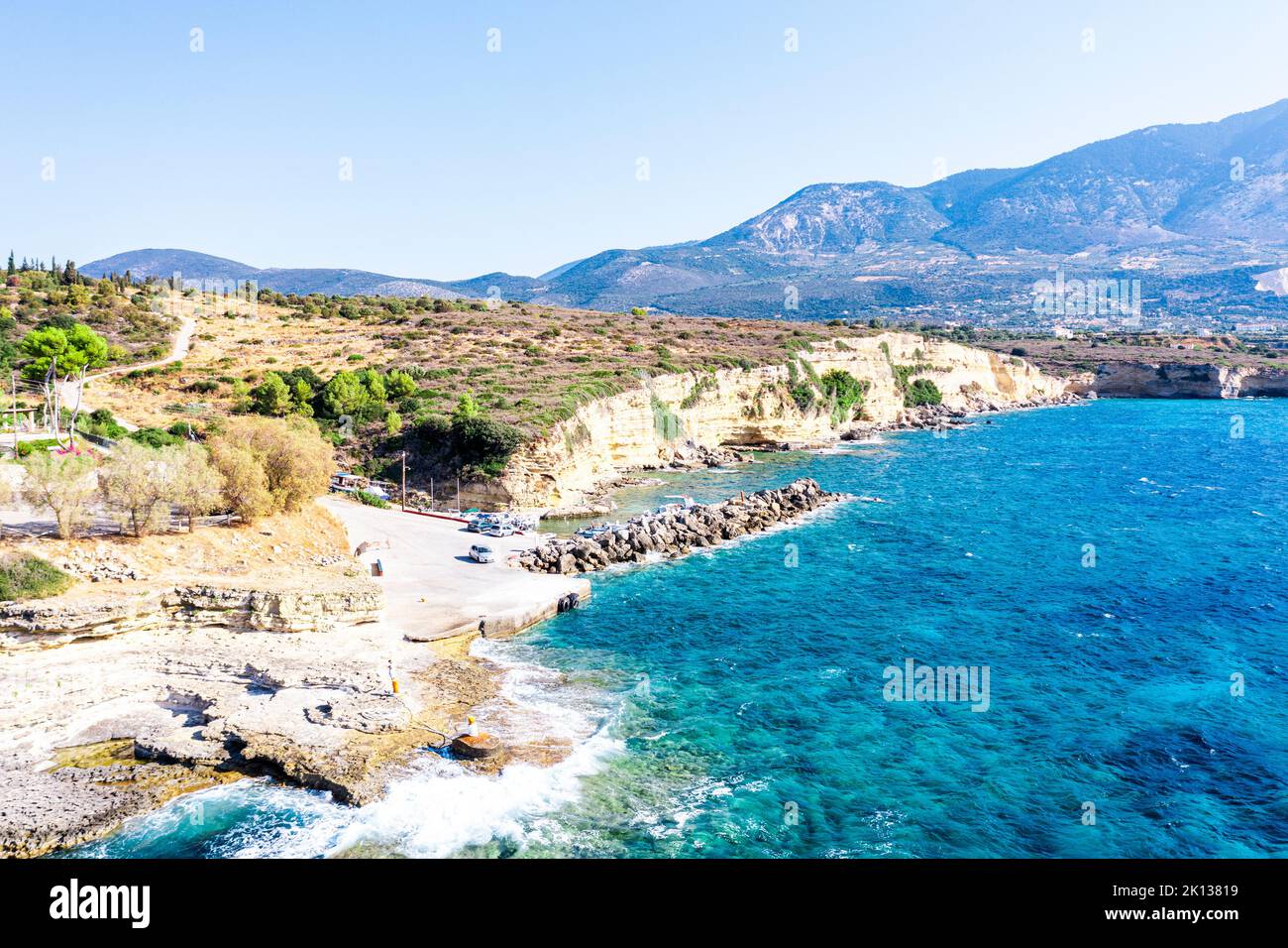 Wellen des türkisfarbenen Meeres, die am kleinen Hafen von Pessada auf Felsen krachen, Luftaufnahme, Kefalonia, Ionische Inseln, griechische Inseln, Griechenland, Europa Stockfoto