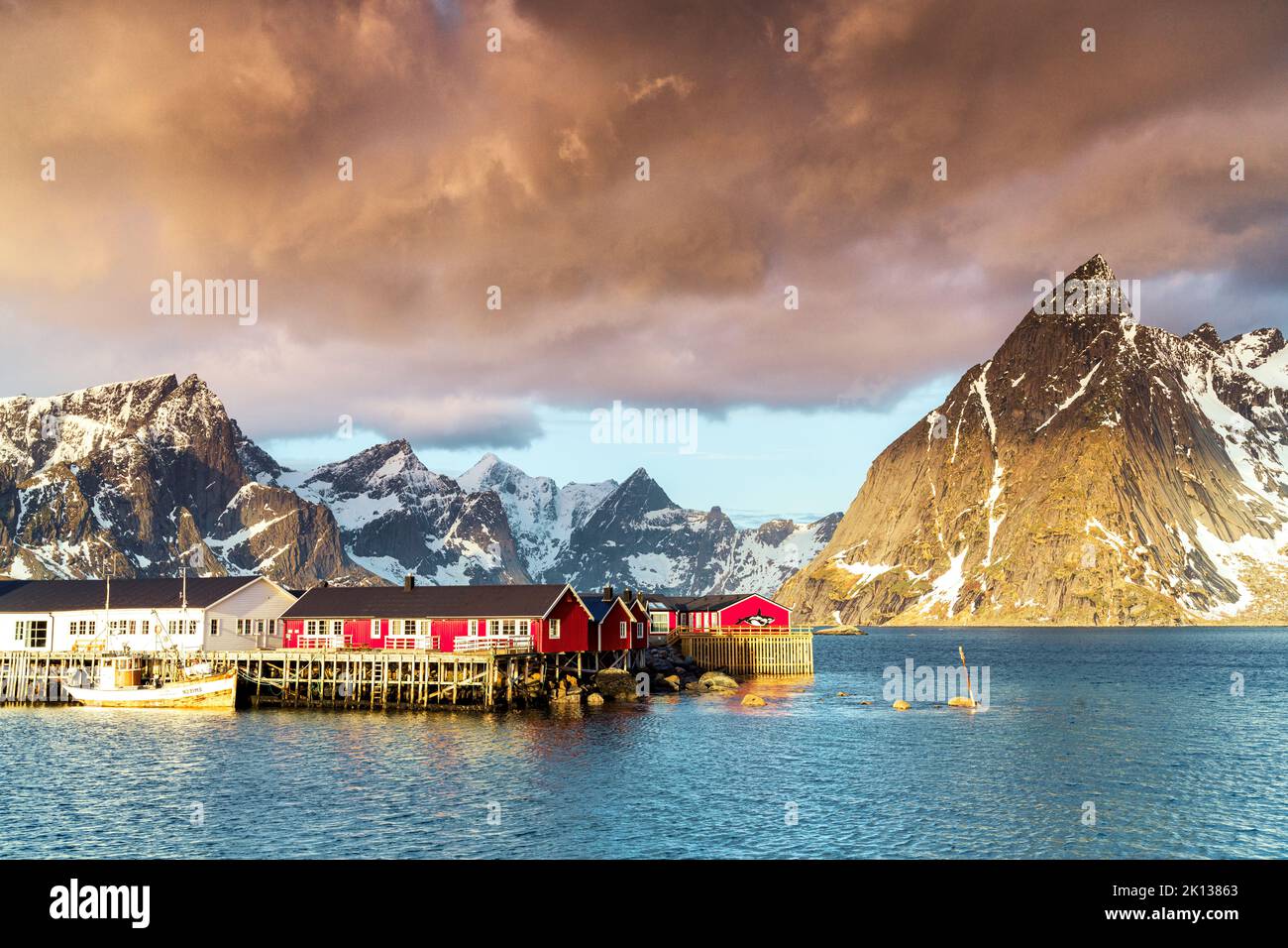 Gewitterwolken im Morgengrauen über Berggipfeln und Fischerdorf Sakrisoy, reine, Nordland County, Lofoten Islands, Norwegen, Europa Stockfoto