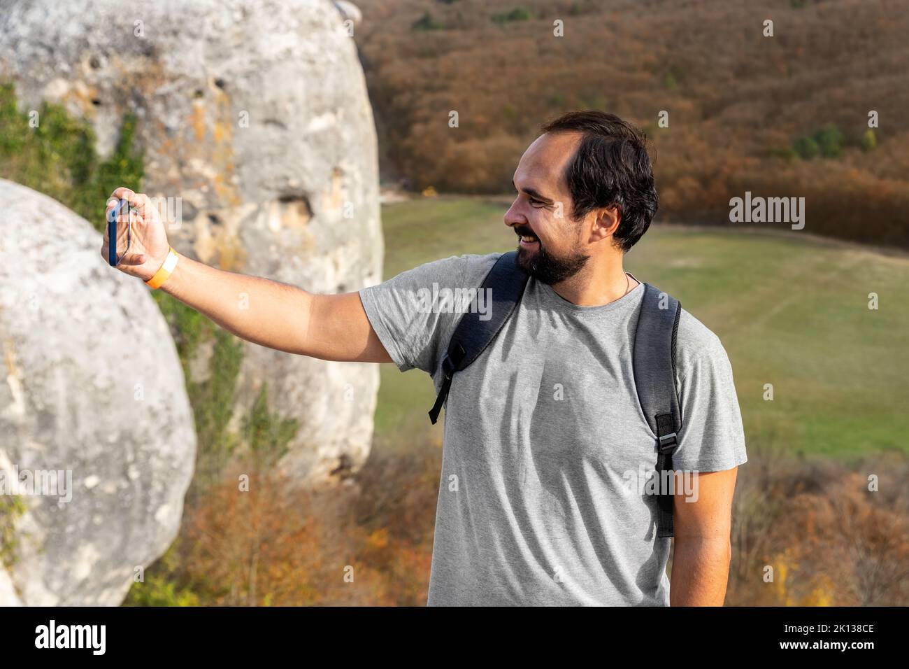 Junge Erwachsene glücklich kaukasischen bärtigen Mann genießen Lächeln und machen Selfie Foto Trekking im Freien Hügel und Berg. Männliche Touristen wandern draußen Stockfoto