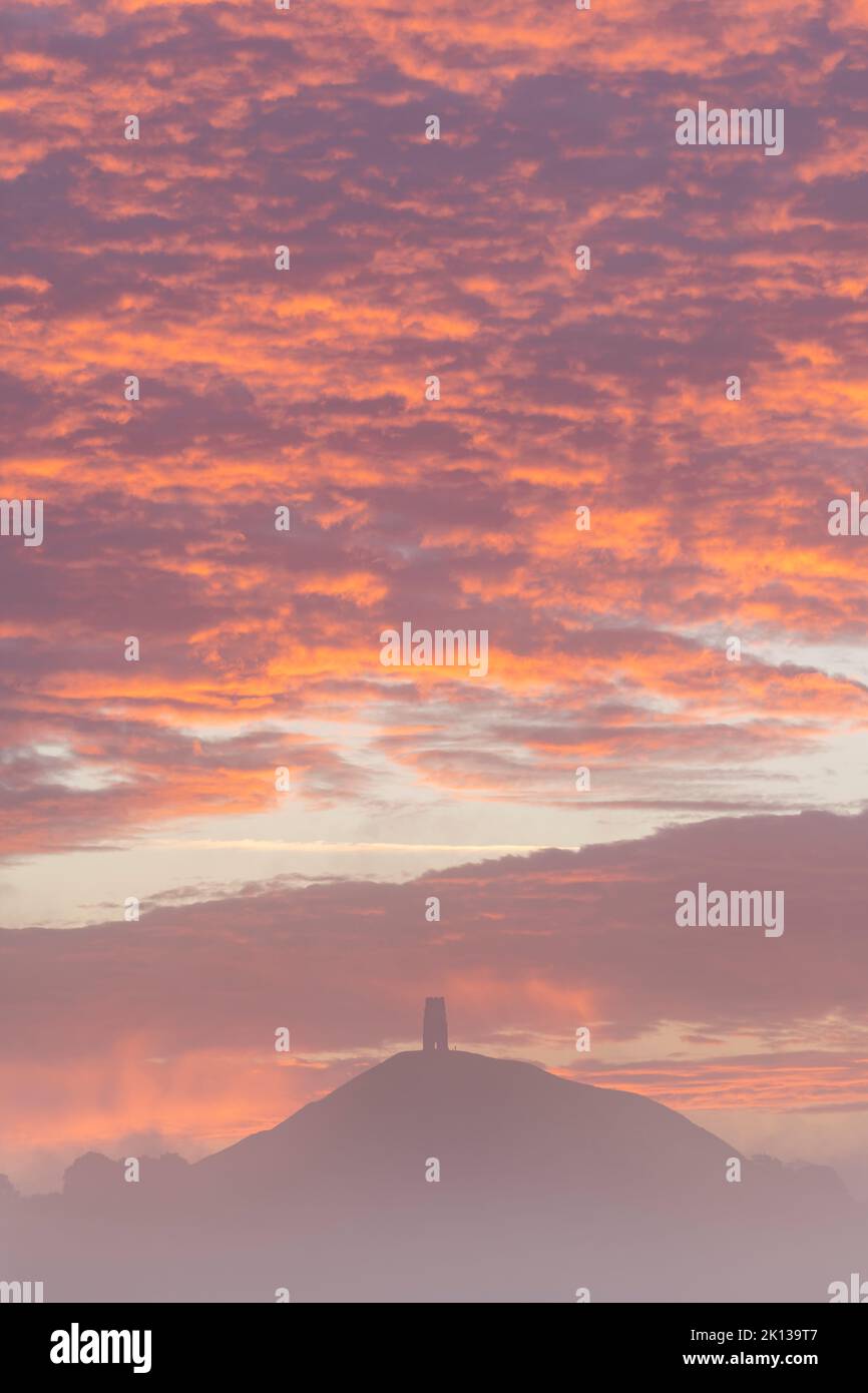 Spektakulärer Sonnenaufgang hinter dem Glastonbury Tor an einem nebligen Herbstmorgen, Somerset, England, Großbritannien, Europa Stockfoto