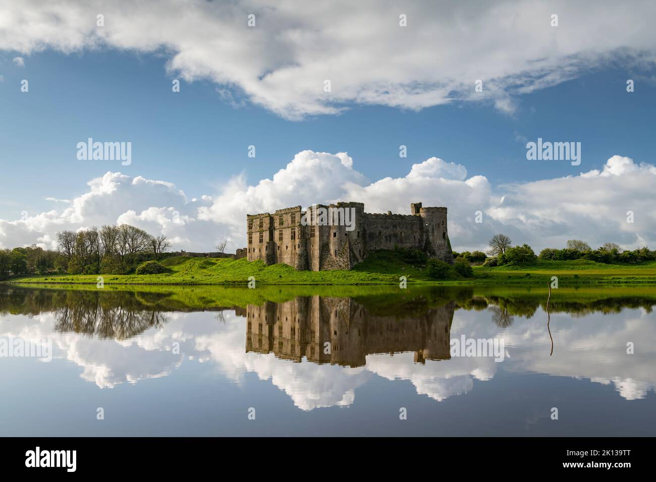 Die prächtigen Ruinen von Carew Castle spiegeln sich im Frühling im Mill Pond, Carew, Pembrokeshire, Wales, Vereinigtes Königreich, Europa Stockfoto