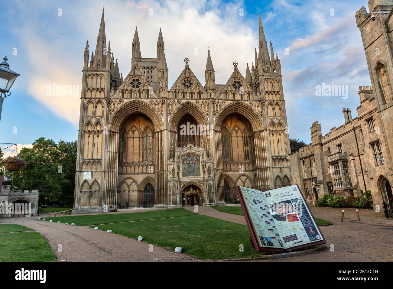 PETERBOROUGH CATHEDRAL, GROSSBRITANNIEN - 9. SEPTEMBER 2022. Landschaftsarchitektur der Fassade und Tür der Peterborough Cathedral und des Geländes bei Sonnenuntergang Stockfoto