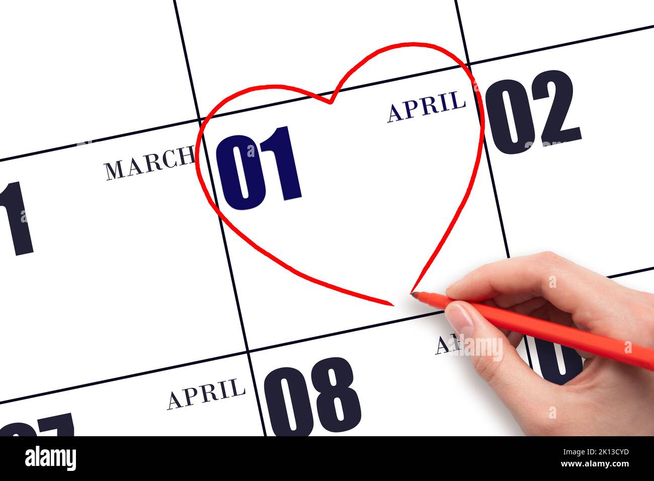 1. Tage im April. Eine Frauenhand, die am Kalenderdatum April 1 eine rote Herzform zeichnet. Herz als Symbol der Liebe. Frühlingsmonat. Tag des Jahres c Stockfoto
