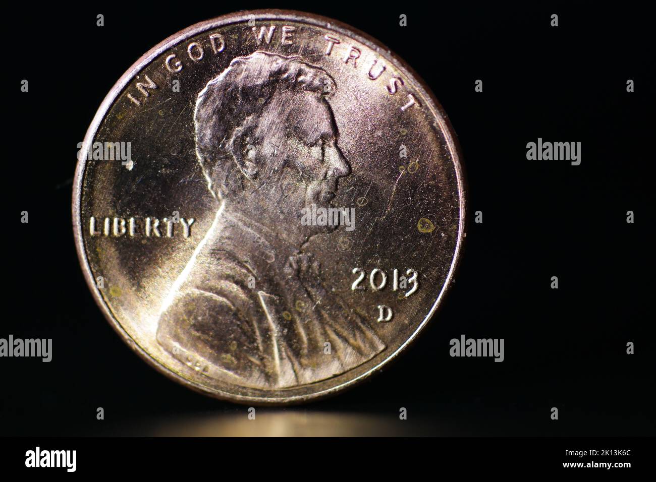 Eine Nahaufnahme von in God We Trust Lincoln Münze isoliert auf schwarzem Hintergrund Stockfoto