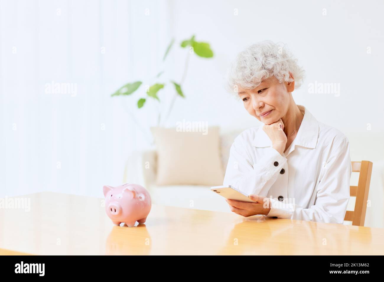 Japanische ältere Frau, die zu Hause Buchhaltung macht Stockfoto