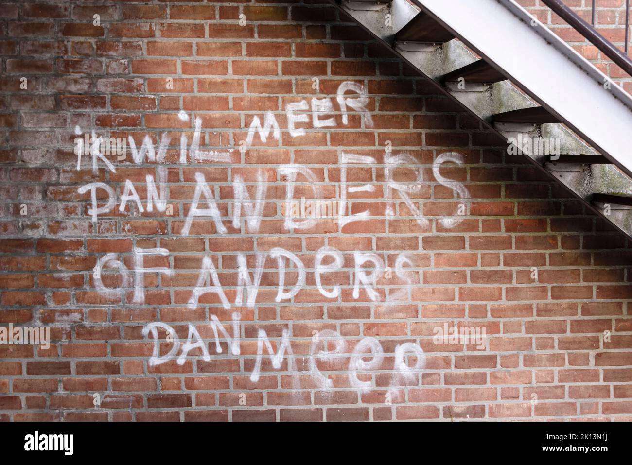 Graffiti auf einer Wand mit der Aufschrift 'Ik wil Meer dan anders of anders dan mee' (Ü: Ich will mehr als anders oder anders als bei mir) Rotterdam, Niederlande Stockfoto