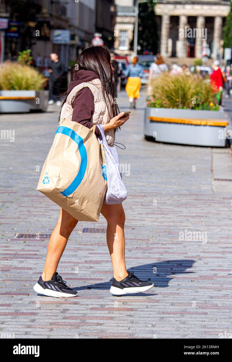 Dundee, Tayside, Schottland, Großbritannien. 15. September 2022. UK Wetter: Aufgrund der warmen Septembersonne erreichten die Temperaturen im Nordosten Schottlands 16 Grad Eine Woche vor dem Herbst sind trendige Frauen im Stadtzentrum von Dundee unterwegs, genießen das angenehme warme Wetter und gehen beim Einkaufen ihre Geschäfte durch. Kredit: Dundee Photographics/Alamy Live Nachrichten Stockfoto
