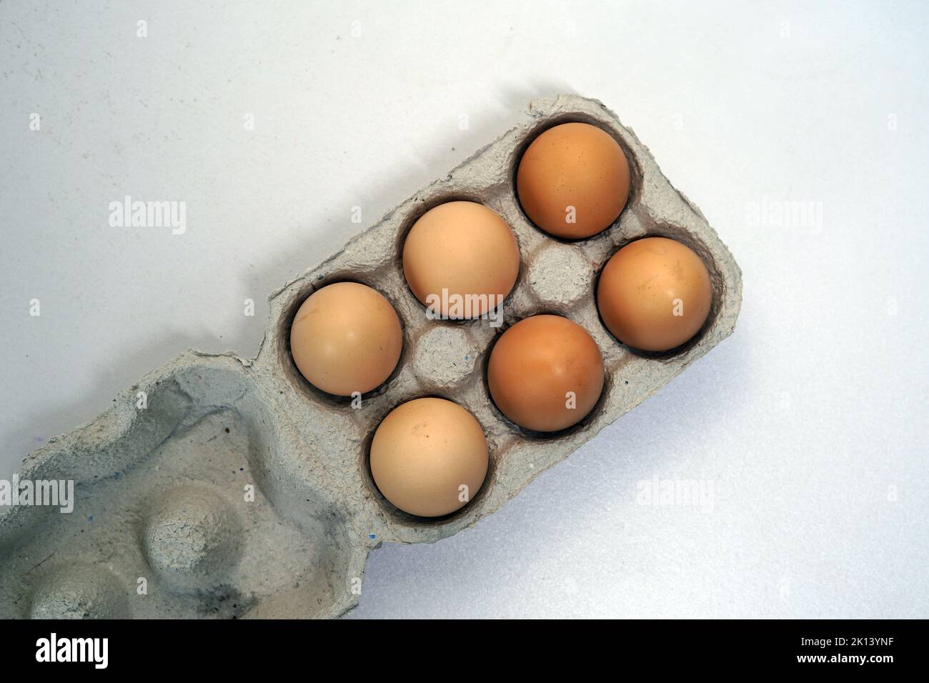Top Shot of Chicken Braten Sie frische Eier in einer Papierschachtel. Ein Eierkarton mit zehn Eiern. Stockfoto