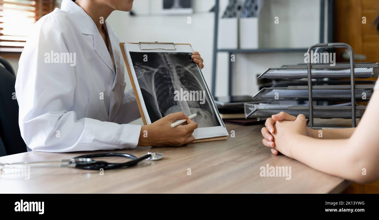 Arzt, der dem Patienten in der Klinik das Röntgenergebnis zeigt Stockfoto