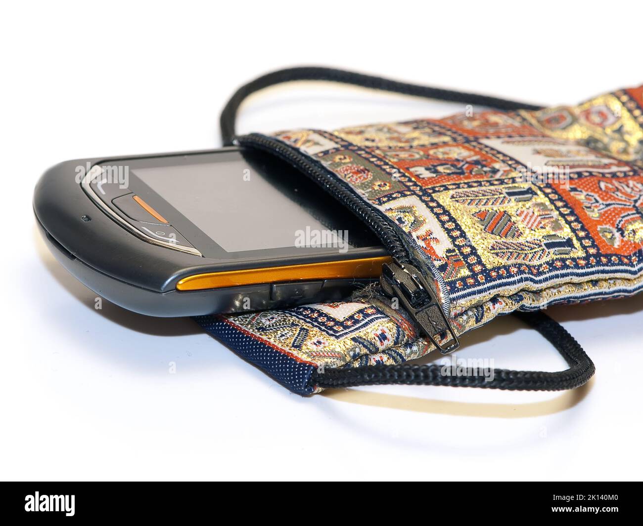 Isolieren Sie die Sicht auf ein Mobiltelefon in einer orientalischen Stickertasche Stockfoto