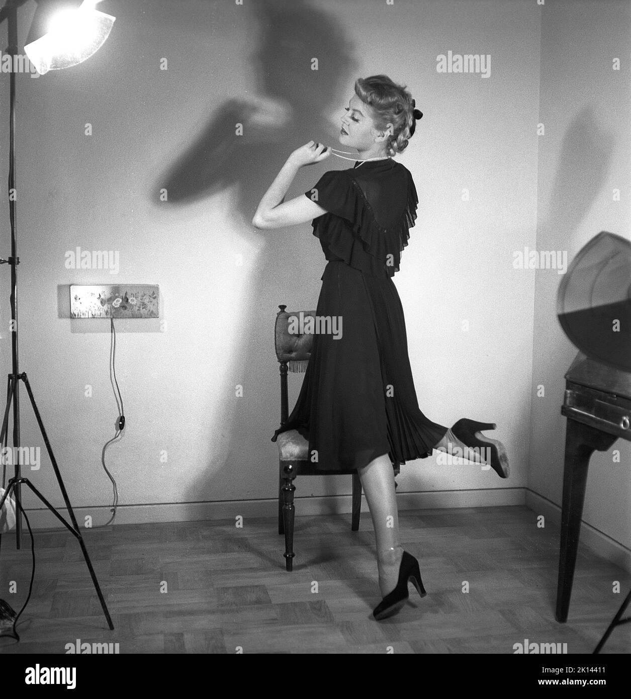 Damenmode im Jahr 1940s. Eine junge Frau, die für ein Damenmagazin fotografiert wurde, um die Damenmode von 1945 zu zeigen. Das weibliche Model trägt ein schwarzes Abendkleid in verschiedenen Stoffschichten. Schweden 1945. Kristoffersson Ref. R2-6 Stockfoto