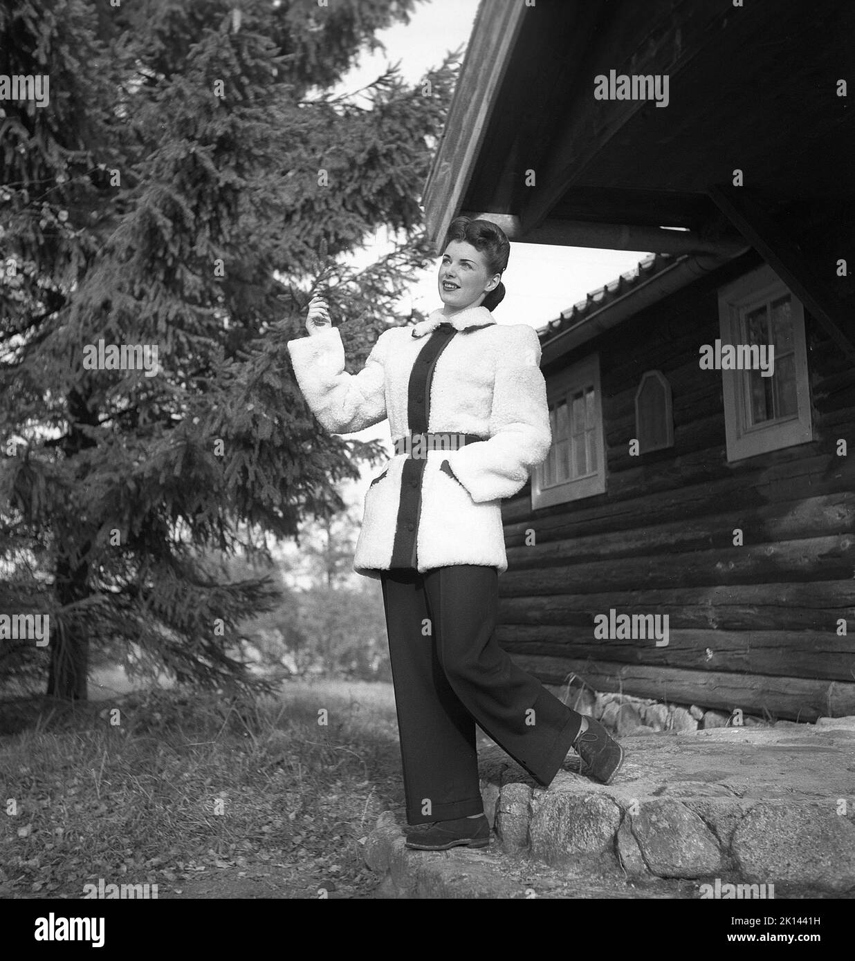 Damenmode im Jahr 1940s. Eine junge Frau, die für ein Damenmagazin fotografiert wurde, um die Damenmode von 1945 zu zeigen. Das weibliche Modell trägt eine breitbeinige Hose und eine wärmere Wolljacke. Ihre Frisur ist sehr typisch 1940s Stil. Schweden 1945. Kristoffersson Ref. R5-6 Stockfoto