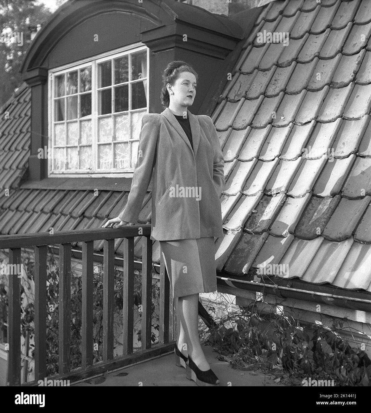 Damenmode im Jahr 1940s. Eine junge Frau, die für ein Damenmagazin fotografiert wurde, um die Damenmode von 1945 zu zeigen. Das weibliche Modell trägt eine passende Jacke und einen passenden Rock. Schweden 1945. Kristoffersson Ref. R6-4 Stockfoto