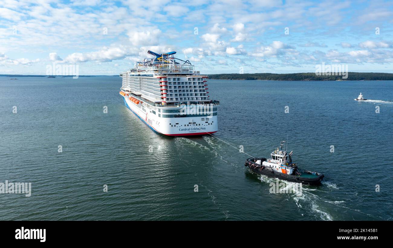 Carnival Cruise Line neues Kreuzfahrtschiff DIE KARNEVALSFEIER macht sich auf dem Weg zu den Seeversuchen durch den finnischen Archipel auf den Weg. Mit Unterstützung des Schleppers Stockfoto