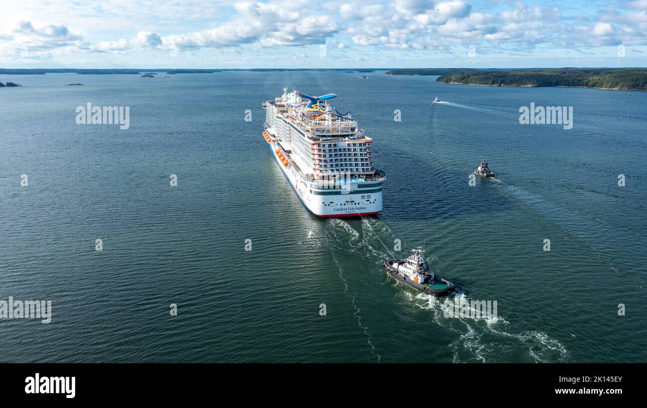 Carnival Cruise Line neues Kreuzfahrtschiff DIE KARNEVALSFEIER macht sich auf dem Weg zu den Seeversuchen durch den finnischen Archipel auf den Weg. Mit Unterstützung des Schleppers Stockfoto
