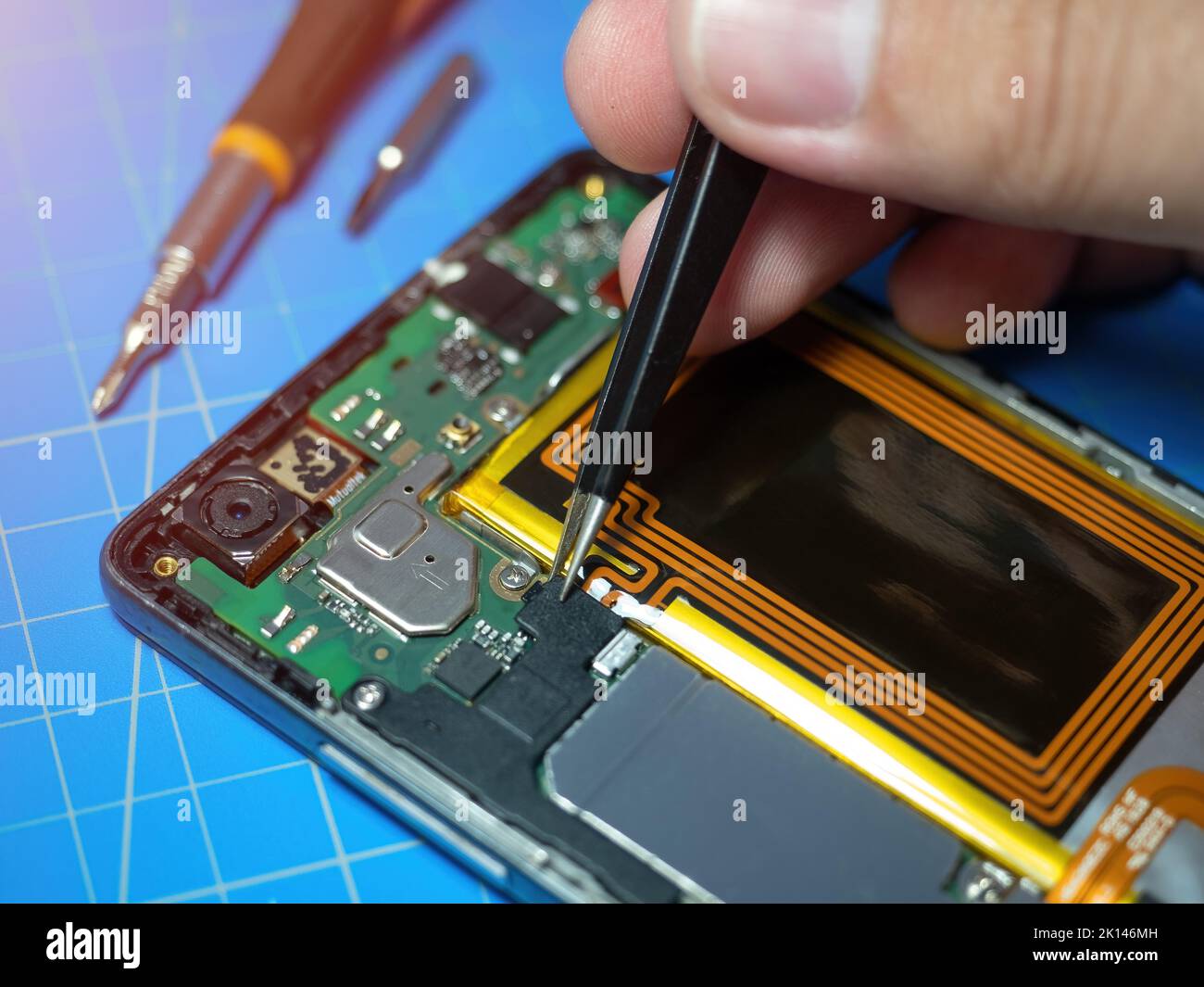 Smartphone-Techniker repariert die Hauptplatine eines Smartphones am Service-Labortisch. Elektronisches Hardware-Upgrade und Reparaturkonzept Stockfoto