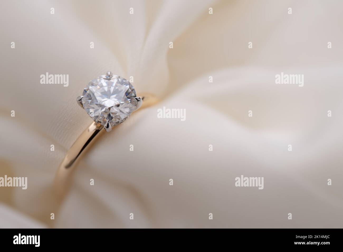 Goldener Hochzeitsring mit Diamant auf weißem weichen Hintergrund Stockfoto