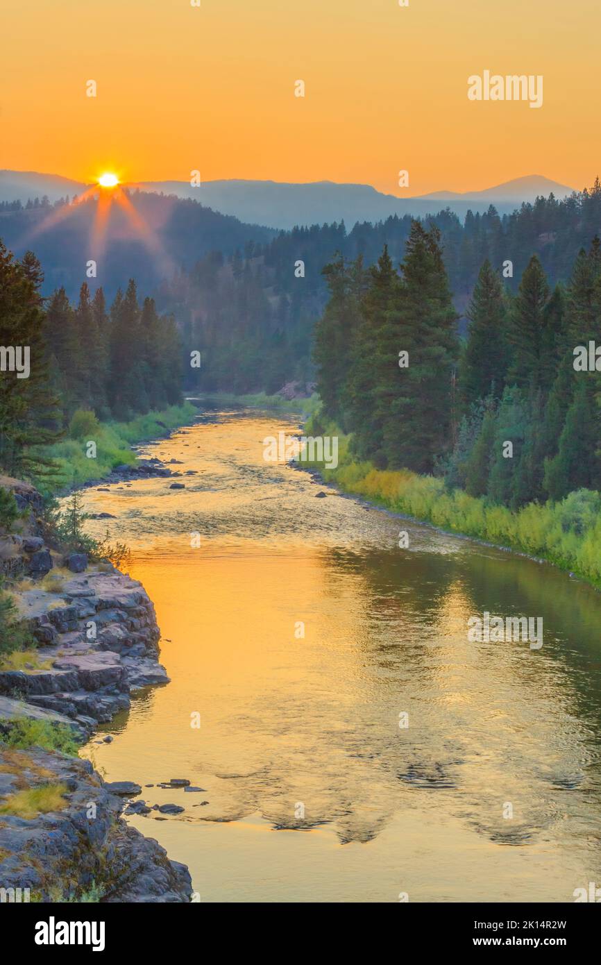 Sonnenuntergang in einem rauchigen Himmel über dem blackfoot-Fluss im Erholungsgebiet johnsrud in der Nähe von potomac, montana Stockfoto