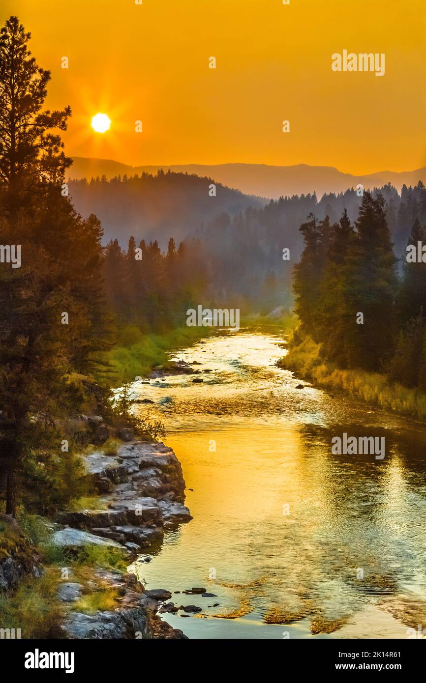 Sonnenuntergang in einem rauchigen Himmel über dem blackfoot-Fluss im Erholungsgebiet johnsrud in der Nähe von potomac, montana Stockfoto