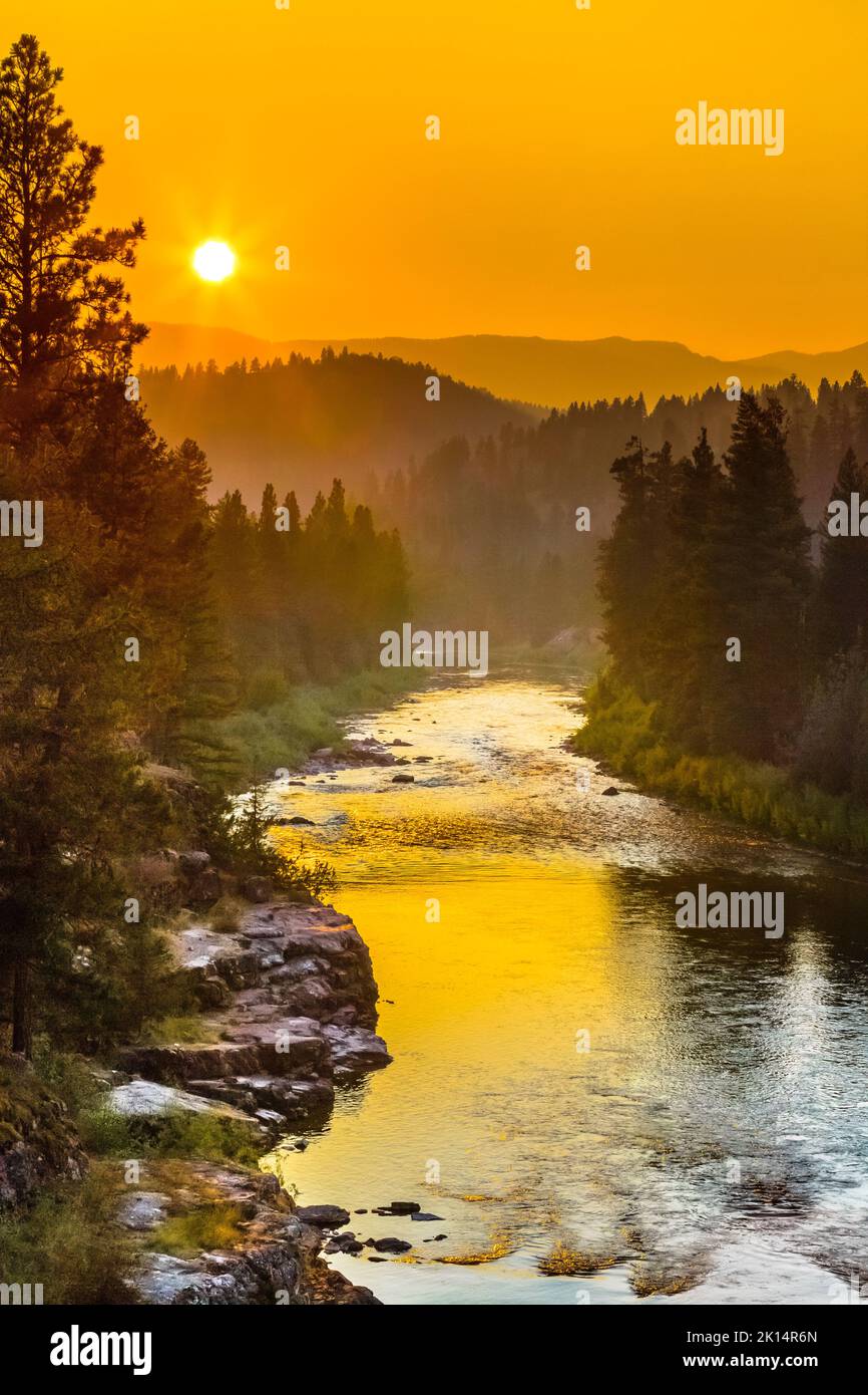 Sonnenuntergang in einem rauchigen Himmel über dem blackfoot-Fluss im Erholungsgebiet johnsrud in der Nähe von potomac, montana Stockfoto