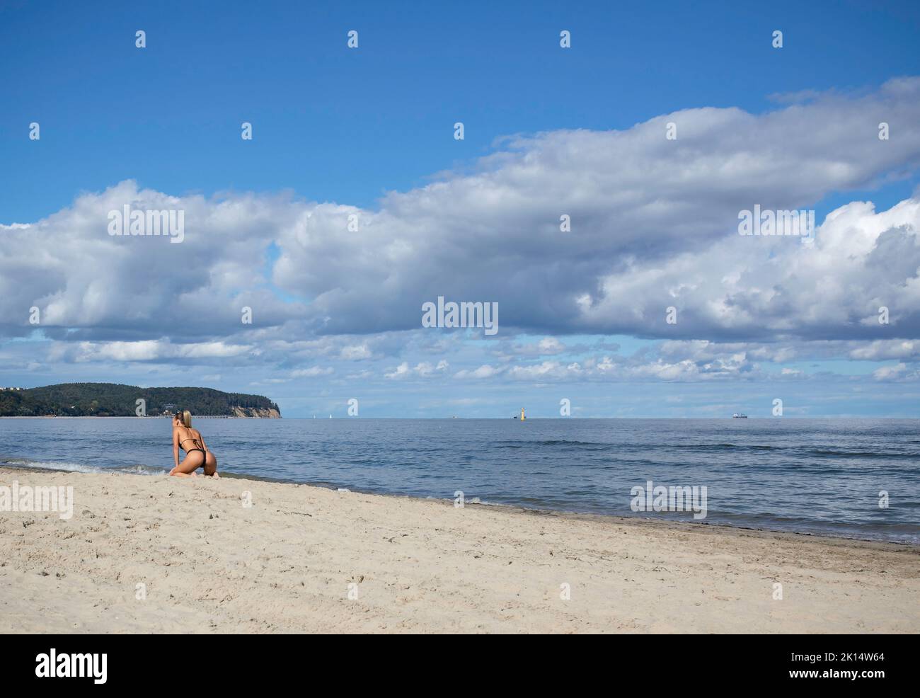 Schöne Frau am Strand, wolkiger Himmel, sonniges Wetter, schöner Boden. Stockfoto