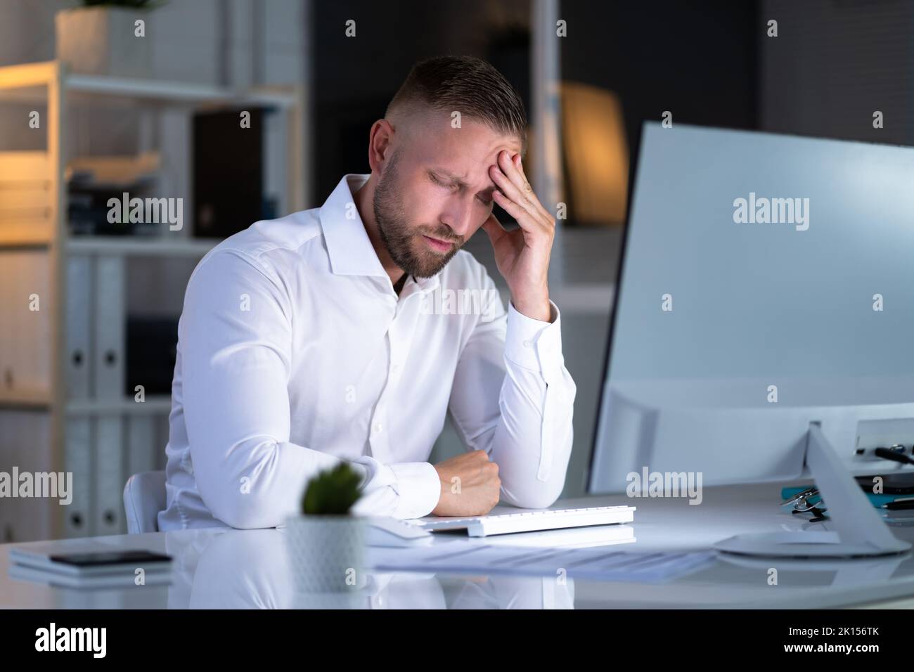 Stressiger Geschäftsmann, Der Spät Am Laptop Im Büro Arbeitet Stockfoto