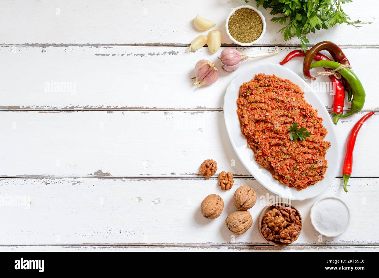 Adjika und Zutaten. Georgische Küche. Frisches Gemüse, Gewürze, Nüsse, Kräuter auf weißem Hintergrund mit Kopierfläche, Draufsicht. Stockfoto