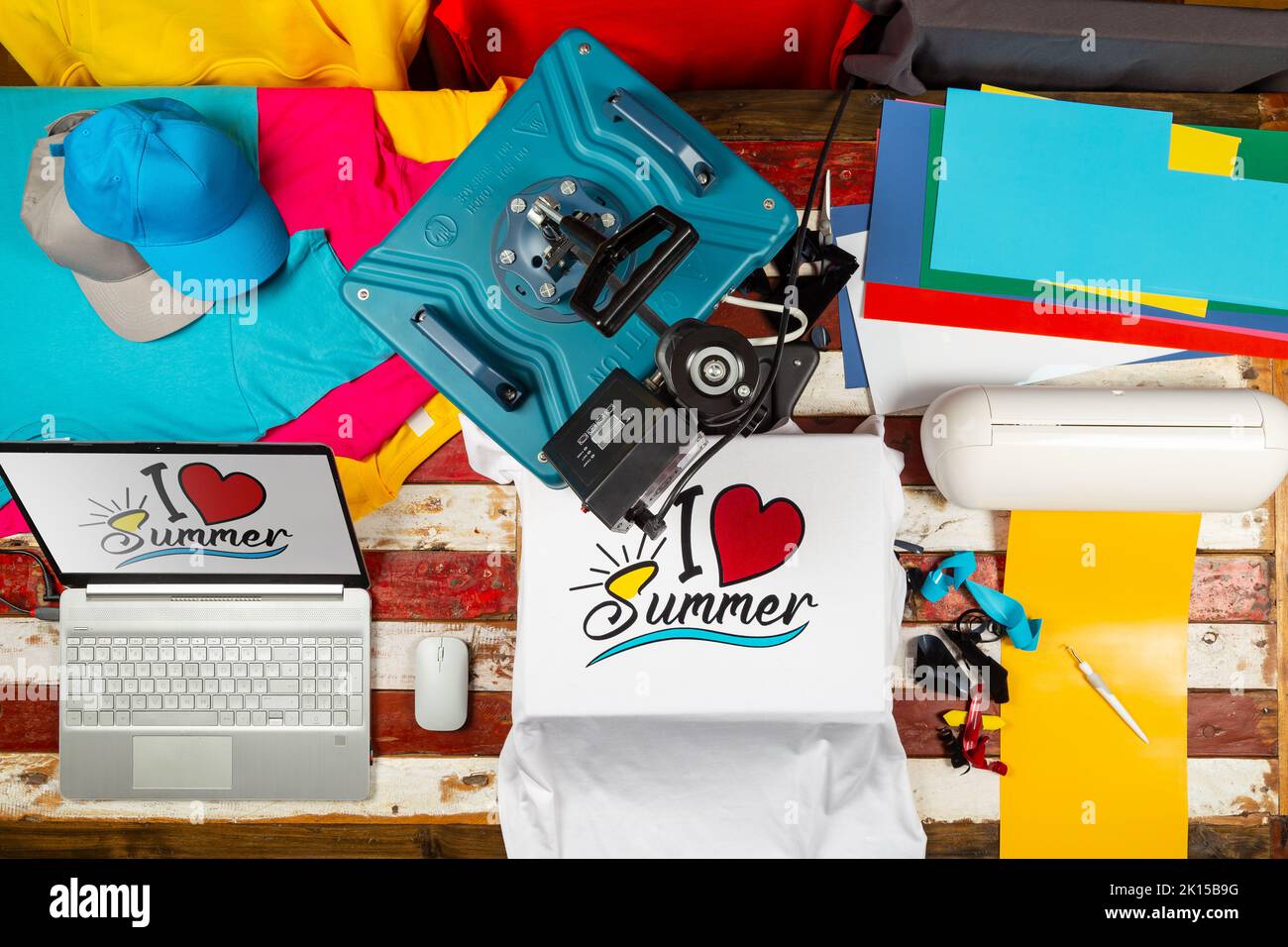 Arbeitsplatz Draufsicht mit Wärmeübertragung Hemdpresse zu fertigen benutzerdefinierte DIY-Design-Shirts mit Notebook-Computer und Schneidemaschine. Startup-Mode Stockfoto