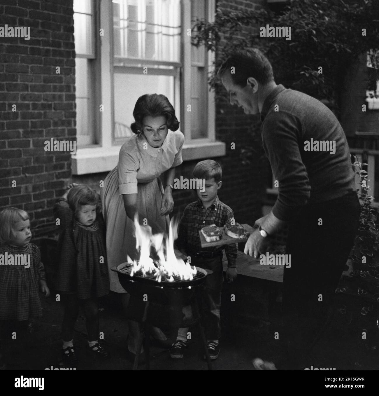 Eine Familie trifft sich für einen Gartengrill. 1956. Stockfoto