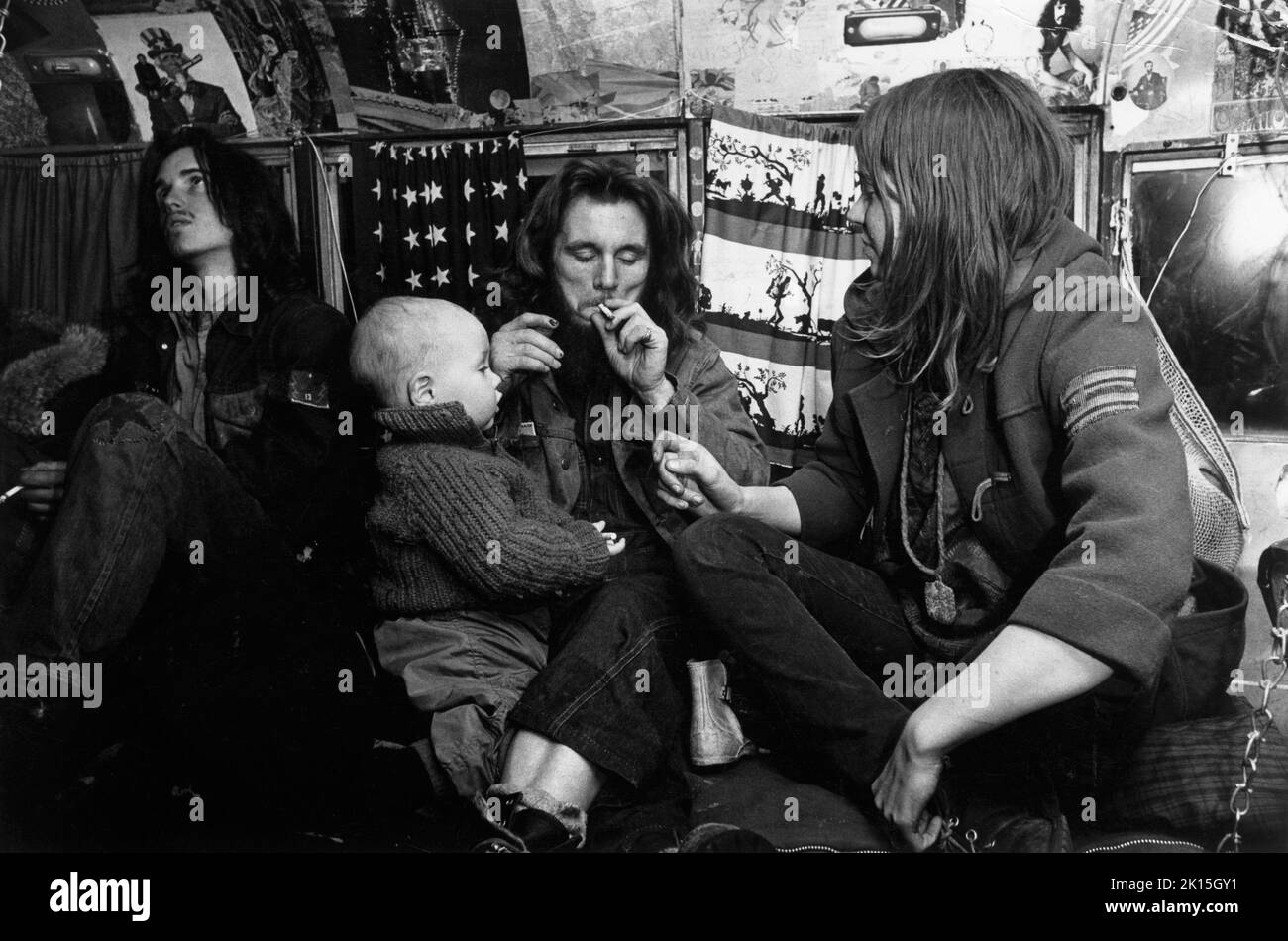 Die Hippie-Familie lebt in einem Bustopf, als ihr Kleinkind 1970 aufschaut. Die Hog Farm, eine Hippie-Gemeinde, wurde mit dem Woodstock Music Festival in Verbindung gebracht. Stockfoto