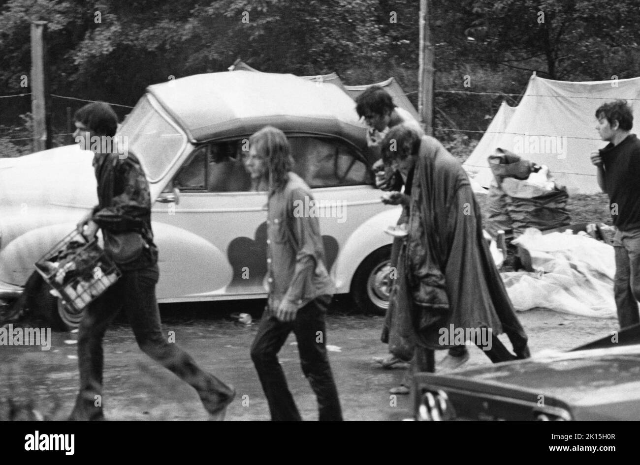 Menschen gehen im Regen während des Woodstock Music Festivals in Bethel, NY; 1969. Stockfoto