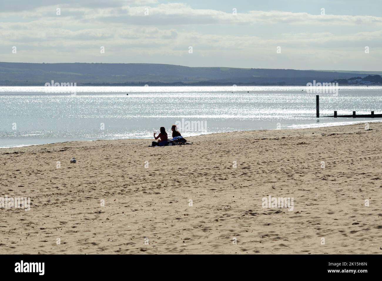 Bournemouth, Dorset, England, Großbritannien, 15.. September 2022, Wetter. Am Nachmittag ist es am Strand ruhig, wenn die Sonne im Frühherbst scheint. Zwei Mädchen sitzen auf dem Sand in viel Platz. Kredit: Paul Biggins/Alamy Live Nachrichten Stockfoto