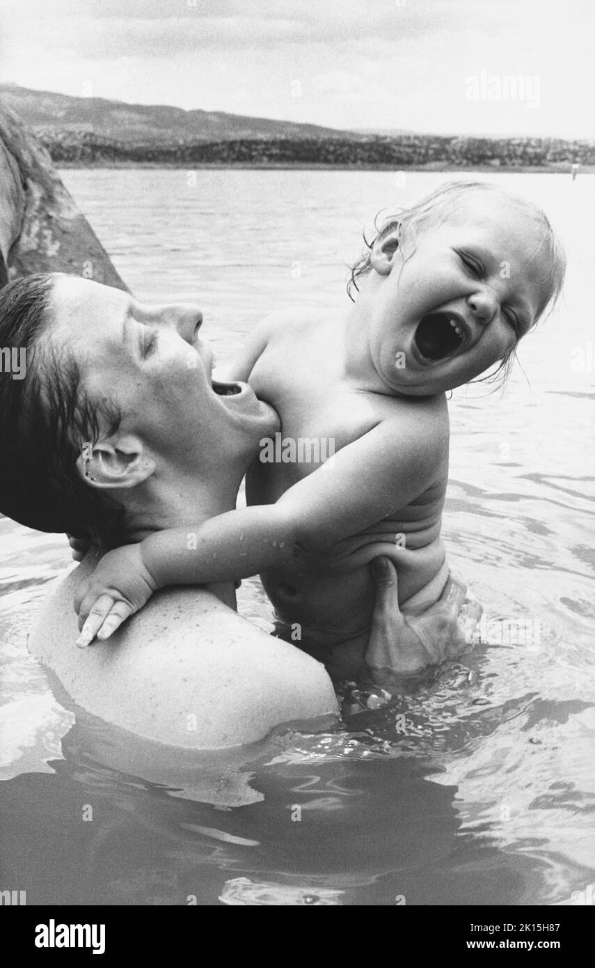 Das Foto ist mit der Bildunterschrift: „das Baby Jessie Jane quietscht vor Freude mit ihrer Tante Lisa, während sie im Abiquiu Lake in New Mexico schwimmen.“ 1989. Stockfoto