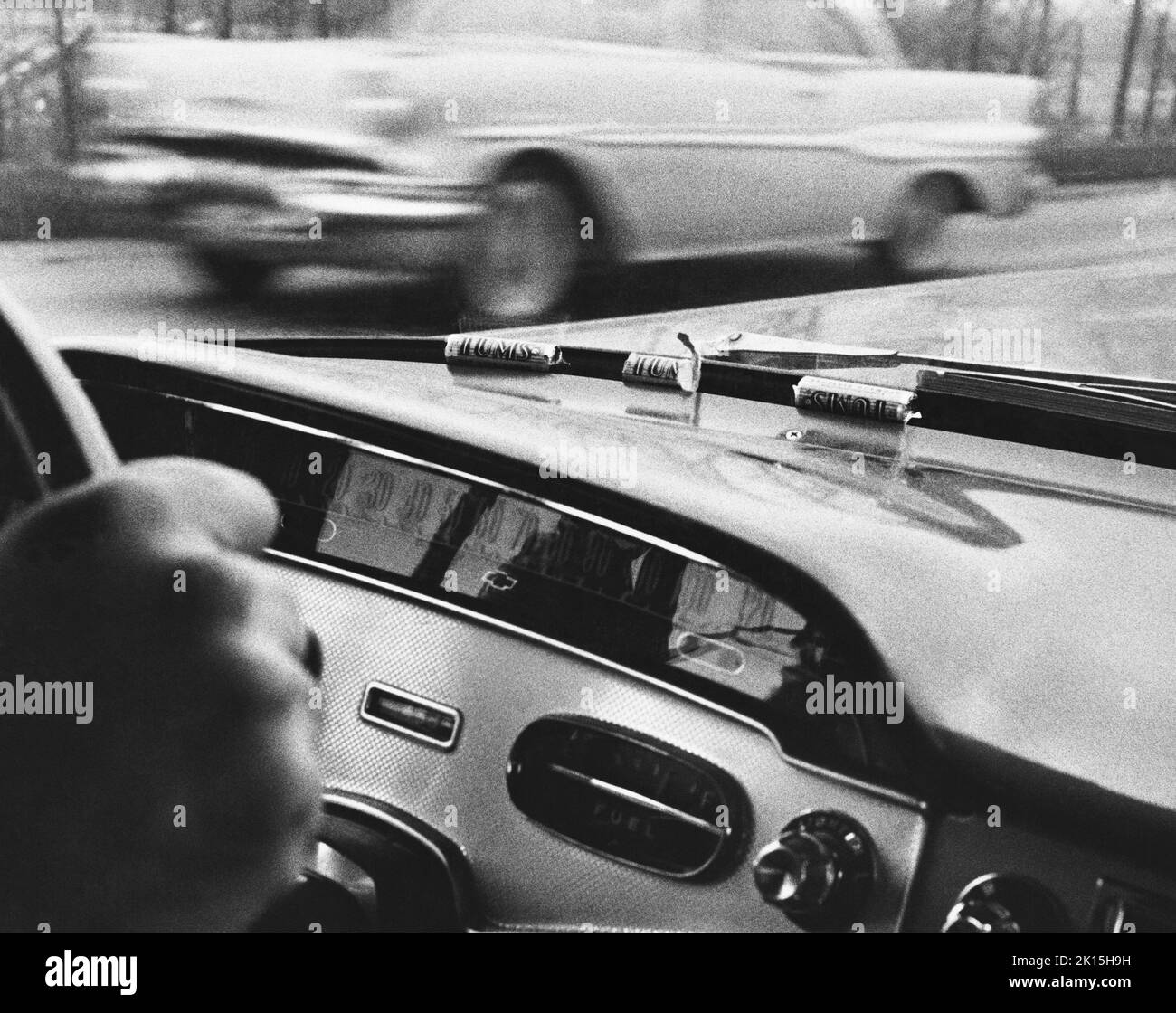 Auf dem Armaturenbrett des Chevrolet aus dem Jahr 1958 eines Reisenden Verkäufers ruhende Tums; undatierte Aufnahme. 1957 Pontiac im Hintergrund. Stockfoto
