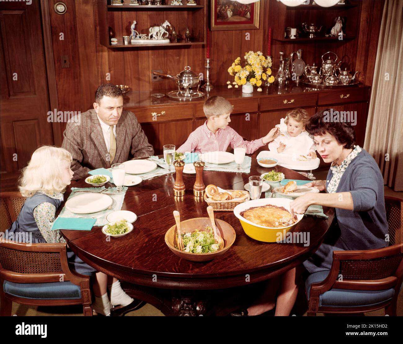 Eine amerikanische Familie, die sich zum Abendessen hinsetzte. Foto aus dem Jahr 1957. Stockfoto