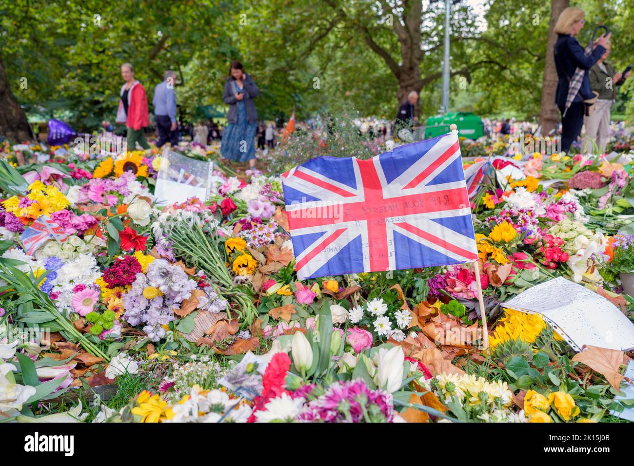 Ihre Majestät Königin Elizabeth Blumen Tribut- Menschen werden abgebildet, wenn sie die Blumen und Karten, die im Green Park, London, hinterlassen wurden, sehen Stockfoto