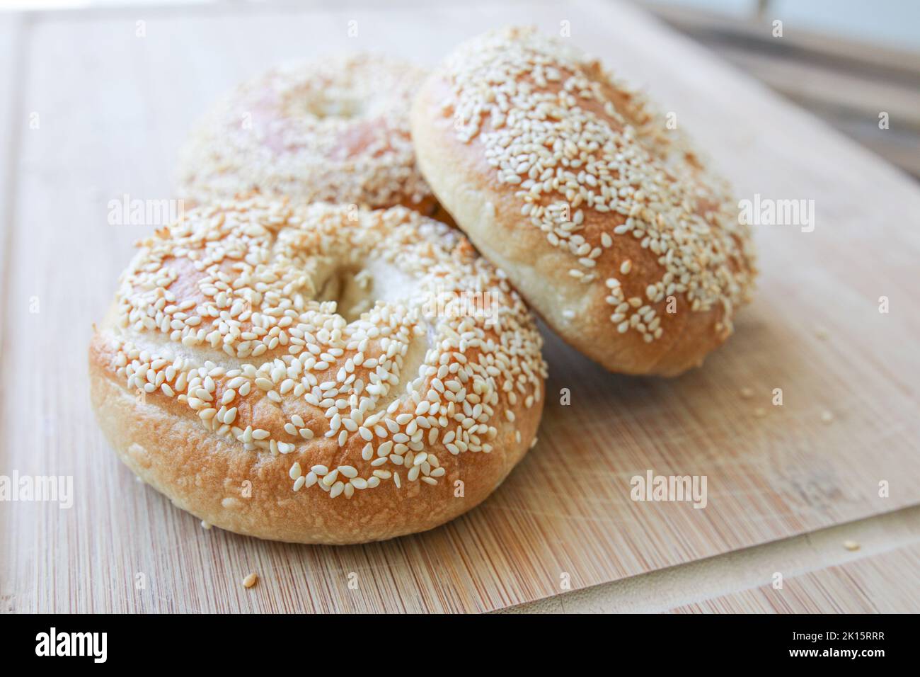 Frische hausgemachte Sesambagels auf einem Schneidebrett Stockfoto