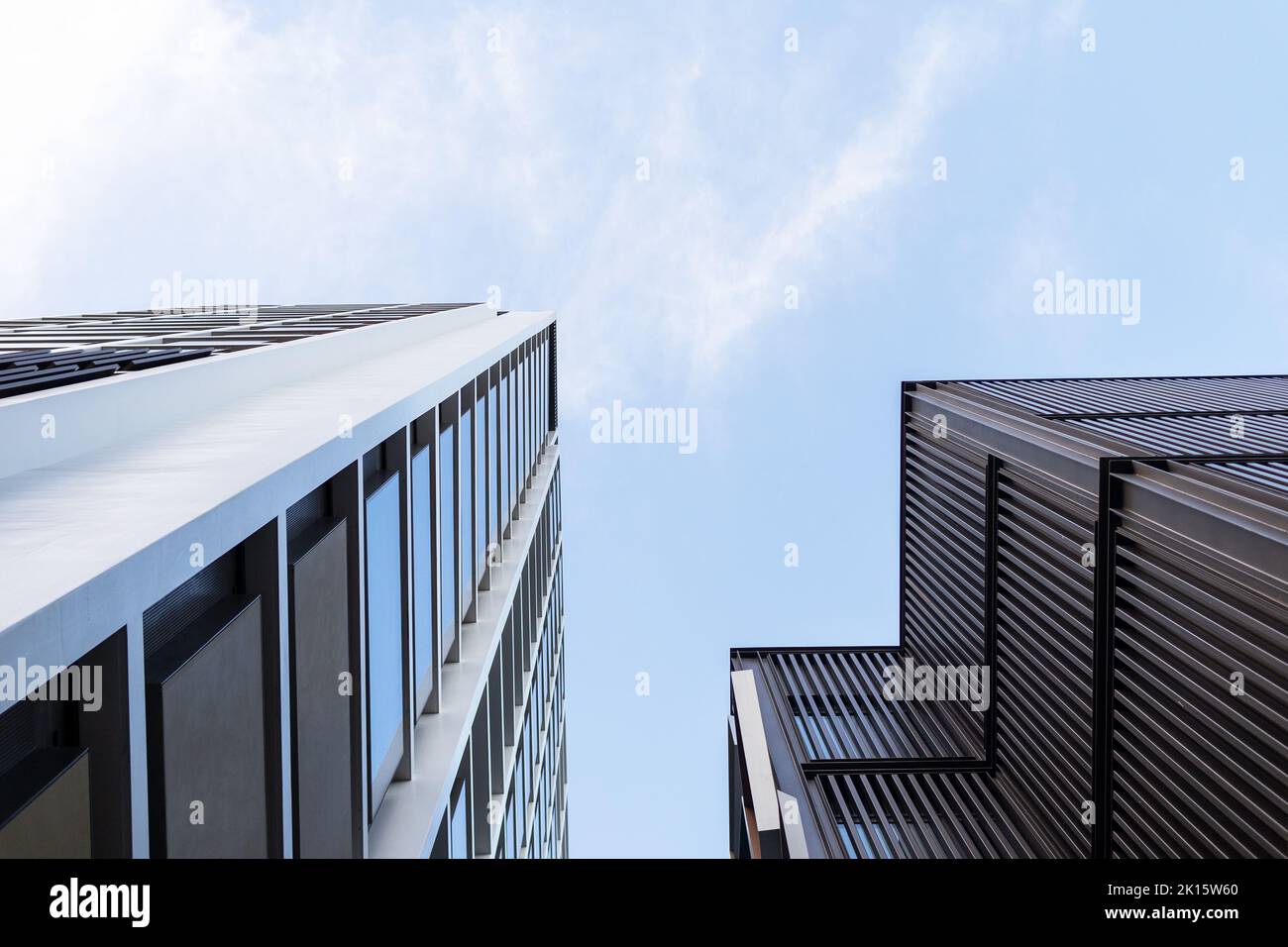 Von der Außenseite des modernen Bürogebäudes aus Glas, das sich an der Straße vor dem klaren, wolkenlosen Himmel im Finanzviertel der Stadt befindet Stockfoto