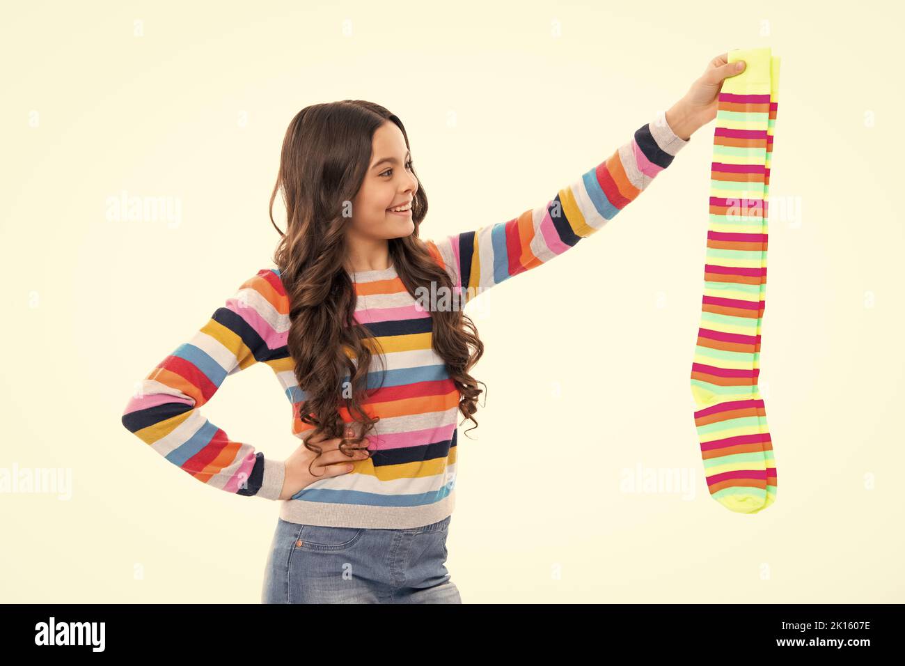 Teen halten Streifen Socke auf weißem Hintergrund. Kind mit einem Paar Socken. Stockfoto