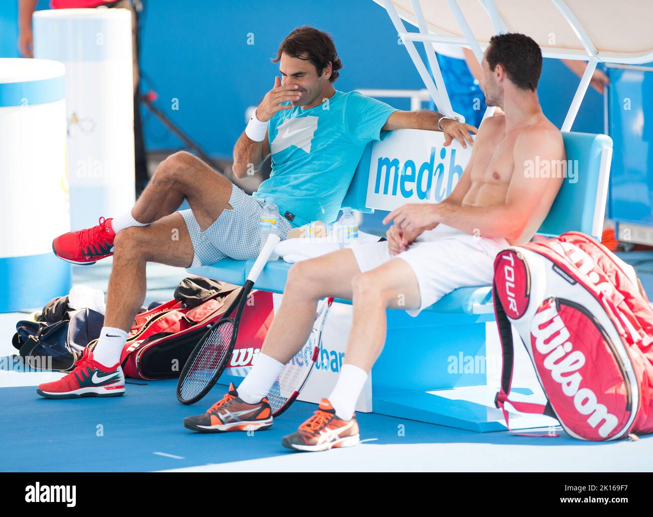 Roger Federer aus der Schweiz kann sich fast einen Tag frei machen, als er auf das Halbfinale der Australian Open 2014 wartet - aber er kommt immer noch in ein kleines Schlagertraining und lacht ein paar Mal mit einem Trainingspartner im Olympischen Park in Melbourne. Stockfoto