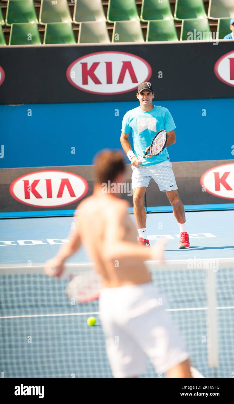 Roger Federer aus der Schweiz kann sich fast einen Tag frei machen, als er auf das Halbfinale der Australian Open 2014 wartet - aber er kommt immer noch in ein kleines Schlagertraining und lacht ein paar Mal mit einem Trainingspartner im Olympischen Park in Melbourne. Stockfoto