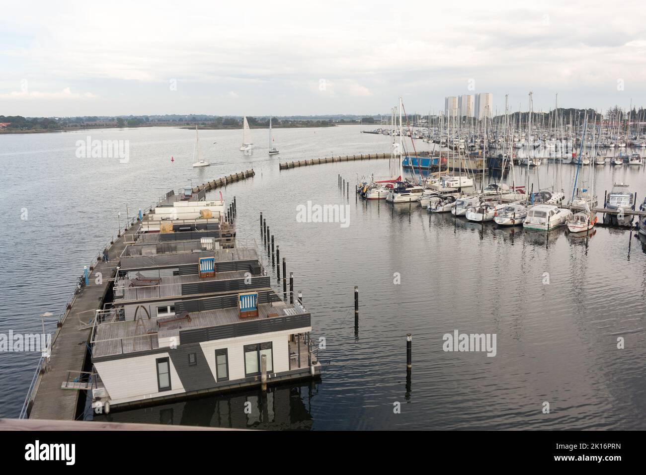 Fehmarn - Hafen von Burgtiefe - Eine ruhige Jachtszene mit schwimmenden Hausbooten und Segelbooten an einem modernen Hafen mit Blick auf das ruhige Wasser. Stockfoto