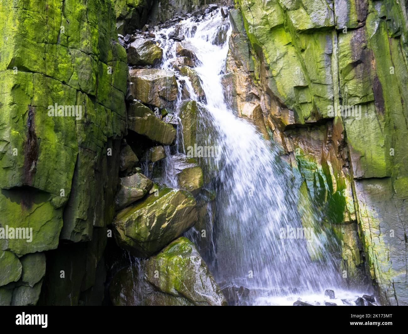 Spektakuläre Aussicht auf einen Wasserfall auf einem Gletscher. Die Vogelklippe Alkefjellet ist die berühmteste Klippe des Spitzbergen-Archipels. Hinloopen Fjord, Spitzbergen. Stockfoto