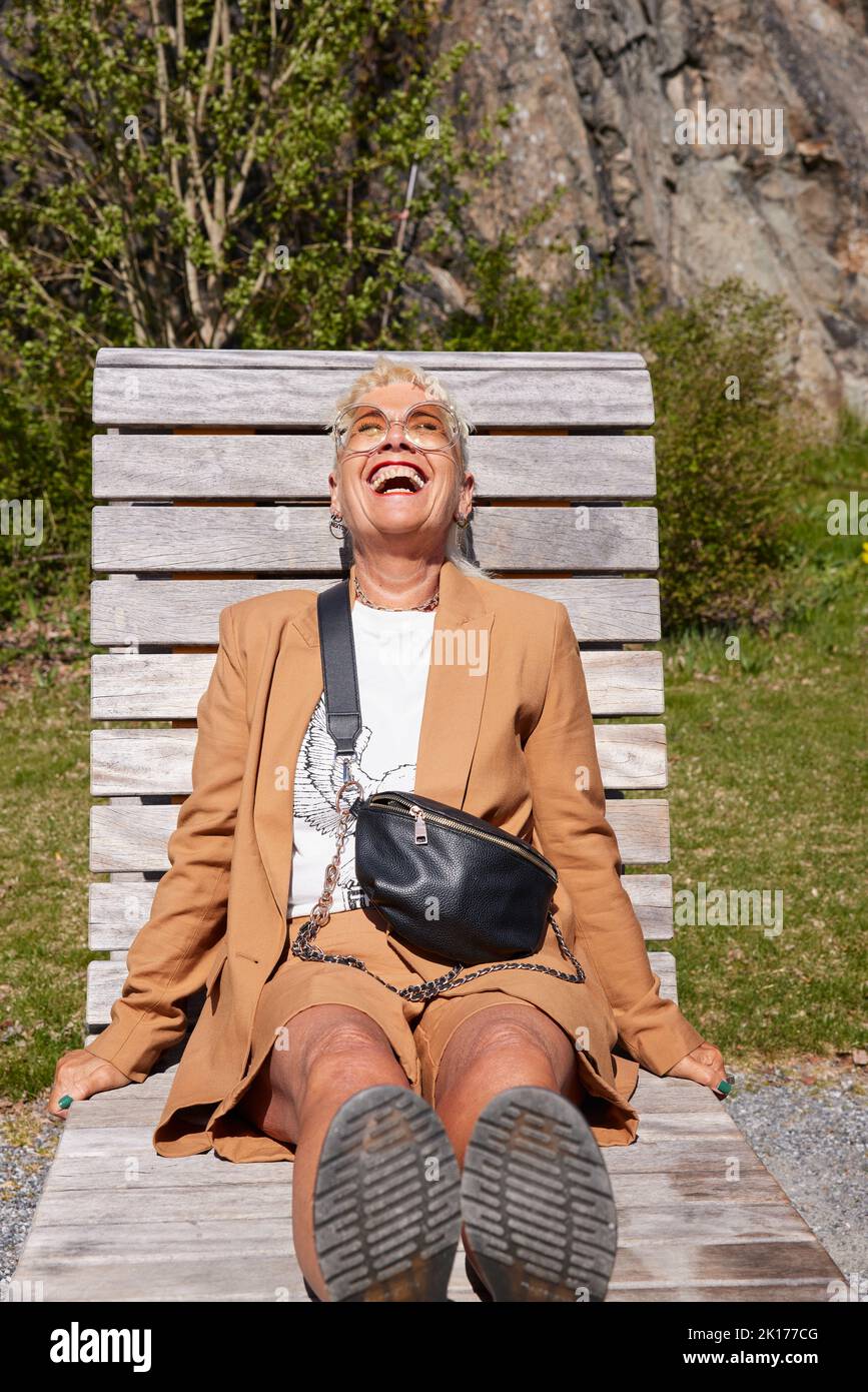 Reife Frau, die sich auf der Sonnenliege entspannt Stockfoto