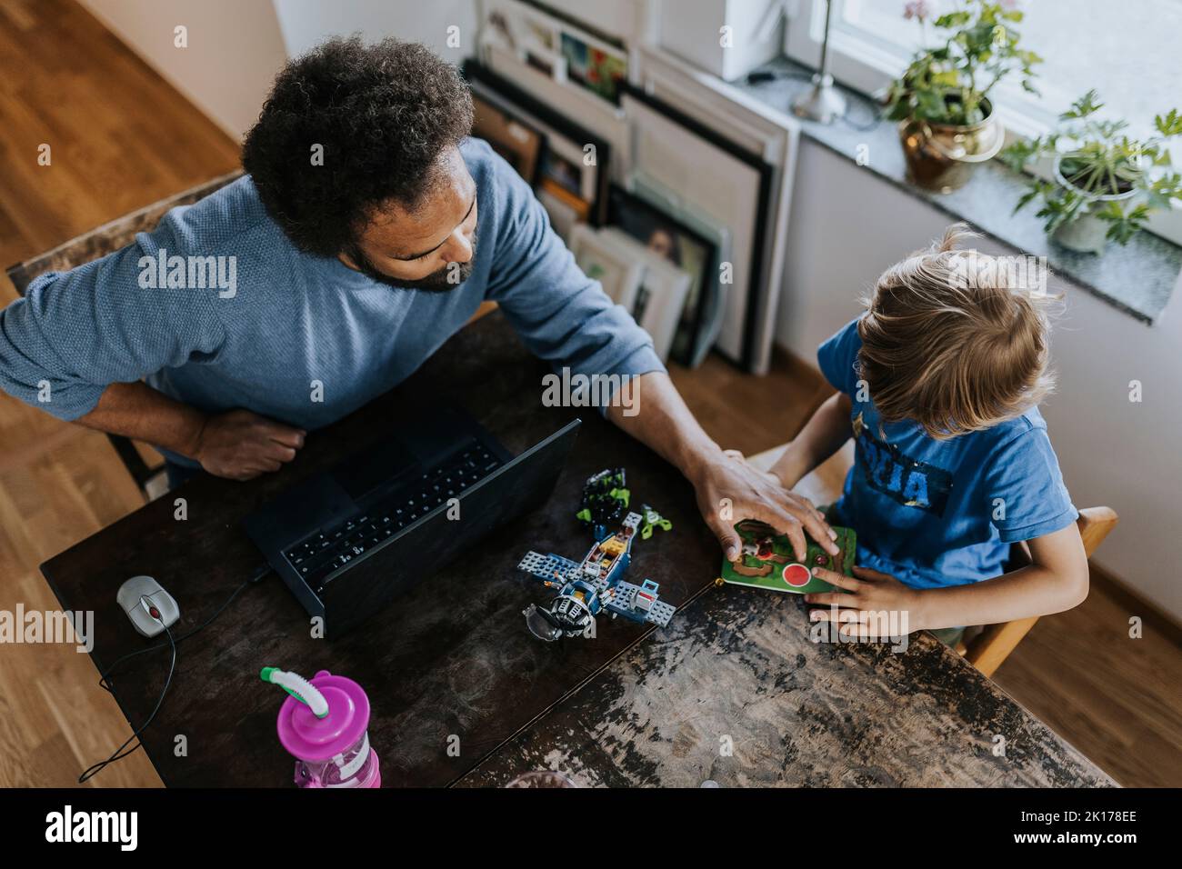 Vater arbeitet von zu Hause aus und spielt mit dem Sohn Stockfoto
