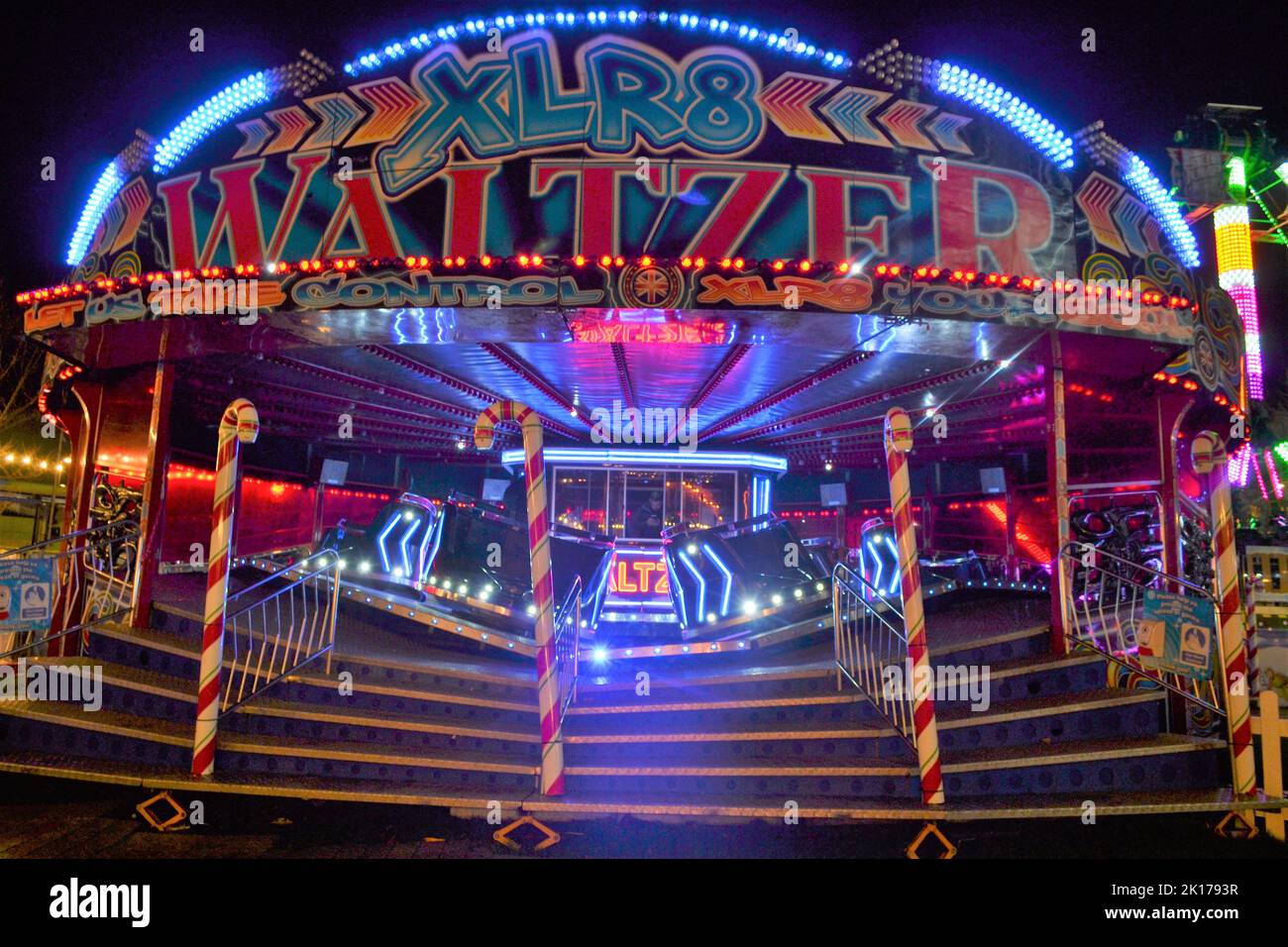 Waltzer Funfair Fahrt bei Nacht mit hellen blinkenden Lichtern - Fast Fair Ride - Spinning Around in A Circle - Thrill Seekers Ride - Brighton - UK Stockfoto