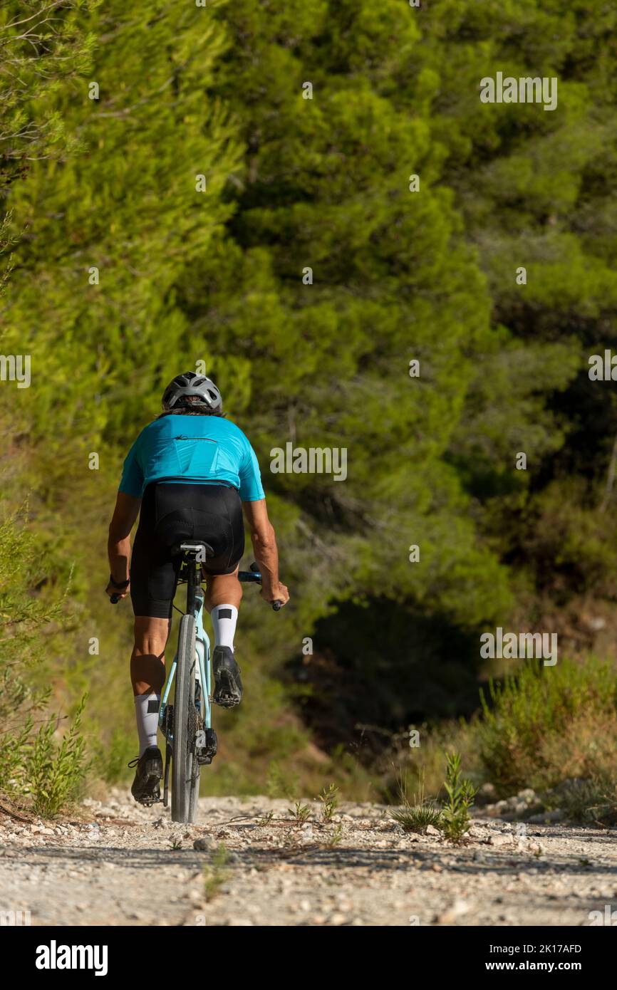 Ein Radler auf einer Schotterstraße mit dem Fahrrad in den Bergen der Costa Blanca, Alicante, Spanien Stockfoto