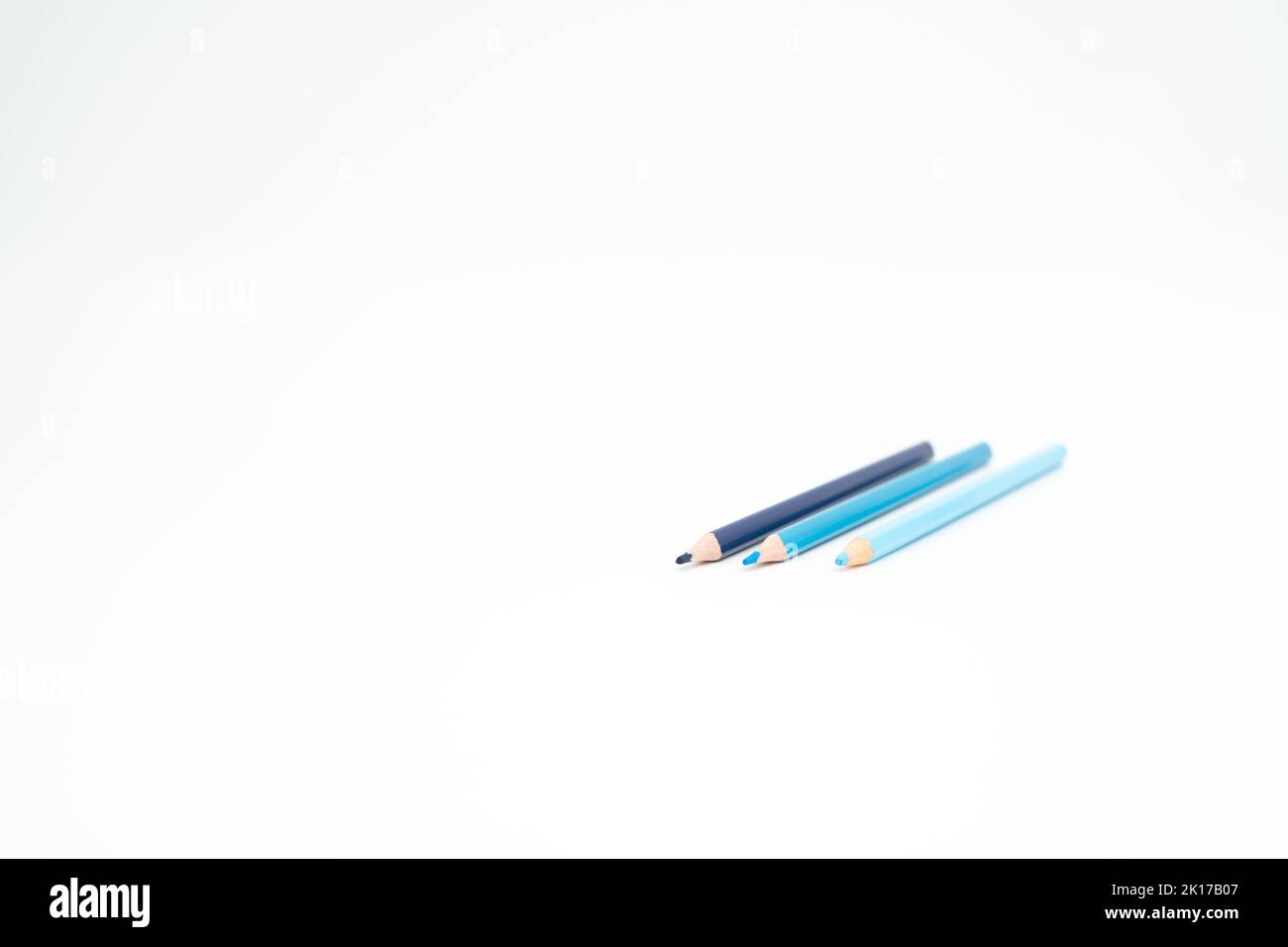 Blaue Buntstifte auf weißem Hintergrund mit einem Punkt (Blei) im Fokus Stockfoto