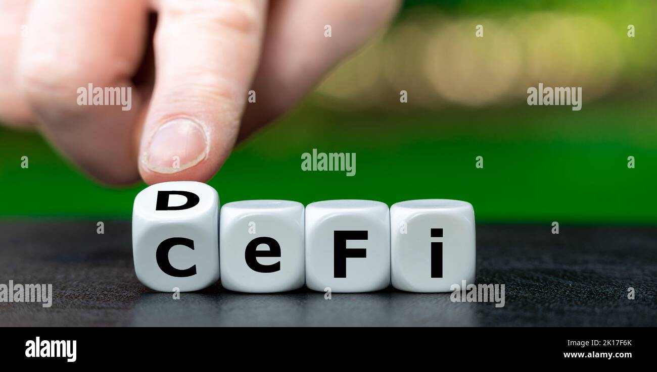 Die Hand dreht Würfel und ändert den Ausdruck „CeFi“ (zentralisierte Finanzierung) in „defi“ (dezentrale Finanzierung). Stockfoto